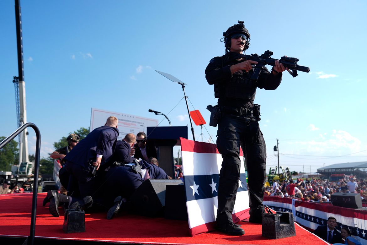 Donald Trump is covered by Secret Service agents. (Evan Vucci/Associated Press)