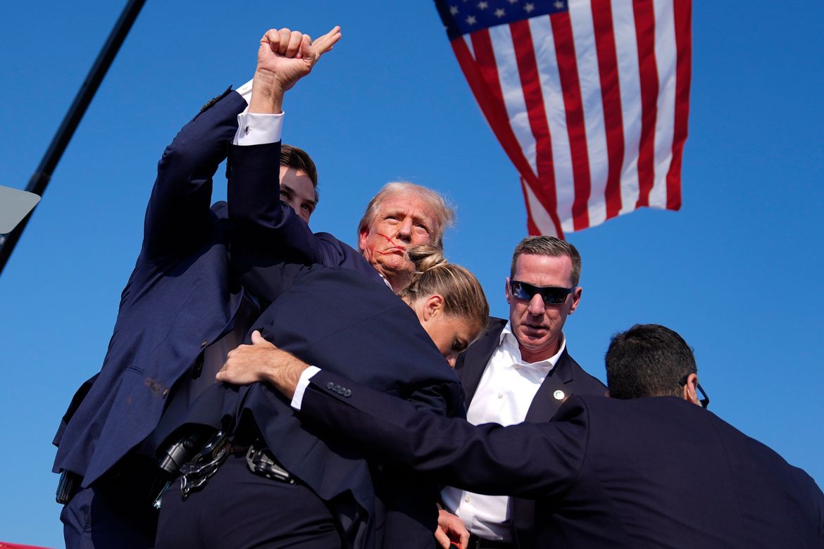 Former President Donald Trump is surrounded by U.S. Secret Service agents at a campaign rally on Saturday in Butler, Pa. (Evan Vucci/Associated Press)